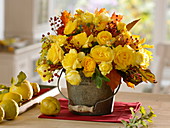 Autumn bouquet in metal bucket, Rose and autumn leaves