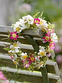 Small wreath of roses and grass hanged on chair back