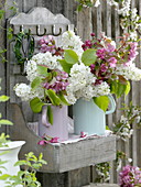 Blossoms of malus and syringa in enameled pitchers