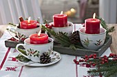 Schneller Adventskranz in weihnachtlichen Tassen mit roten Kerzen, Picea