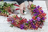 Autumn wreath with violet cushions and red foliage