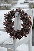 Frozen autumn wreath on chair back: leaves of Quercus (oak), Calluna