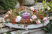 Wreath of pink (roses and rose hips) on a white tray