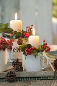 Unusual Advent wreath in enamel cups, decorated with holly