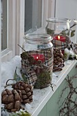 Preserving jars as lanterns on the windowsill with snow