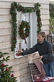 Decorate window with garland and wreath for Christmas
