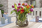 Blooming tulipa bouquet in wide glass with betula branches