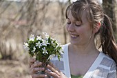 Woman with a little Anemone nemorosa (Wood anemone) bouquet
