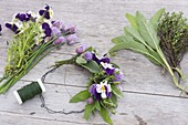 Tying a small wreath of herbs and edible flowers