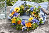 Blue-yellow-orange wreath of edible flowers and herbs
