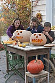 Family carving pumpkins for Halloween