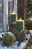 Grüne Kerzen auf Stammstuecken, Mooskugeln, Schlehen , Schnee