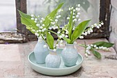 Convallaria (lily of the valley) flowers in small porcelain vases