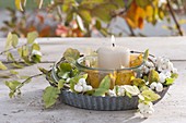 Einmachglas mit Kerze und Herbstlaub als Windlicht