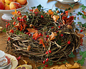Natural autumn wreath of twisted hop hips, pink rose hips, physalis