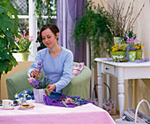 Young woman placing a spring bouquet in the living room