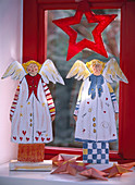 Wooden angel (red + blue) at the window