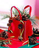 Red felt bag with pinus (pine), twigs and cones