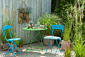 Small seating group on gravel terrace with grasses