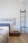 Delicate metal chair used as dressing stand next to bed