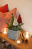 Candle lanterns around arrangement of crocheted fir trees