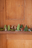 Miniature forest of animal figurines and tiny crocheted trees