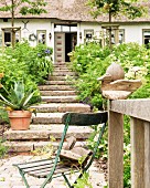 Vintage garden chair, wooden duck and stone steps outside Frisian famhouse