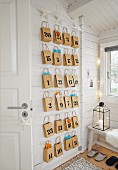 An advent calendar made up of numbered brown paper bags hanging on the wall