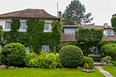 Traditional climber-covered country house in well-tended garden