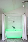 White bathtub with shower curtain bathed in green light in renovated period building