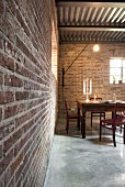 Candlesticks and laptop in illuminated dining area with brick walls