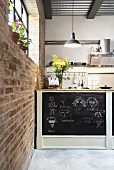 Sideboad with chalkboard back wall in open-plan kitchen