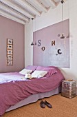 Doppelbett mit lilafarbener Bettwäsche und passender Wanddekoration