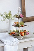 Parrot tulips, touch-me-not, quail eggs and feathers on vintage cake stand