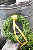 Wreath of rapeseed pods tied with yellow ribbon