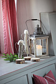 Hand-crafted driftwood angels and candle lantern on windowsill