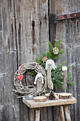 Angels hand-made from driftwood on wooden stool against wooden door