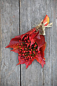 Posy of small rose hips and red Virginia creeper leaves
