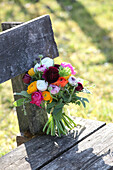 Bouquet of colourful ranunculus on weathered garden bench