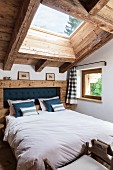 Double bed with rustic headboard in attic bedroom