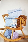 Arrangement of vintage rocking horse, hand-made cushion covers and soft toy