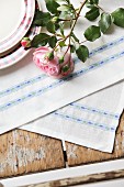 Roses on hand-made place mats with pale blue floral trim