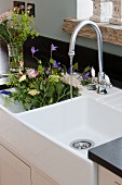 Bouquet of flowers in white, double Belfast sink with vintage-style tap fitting