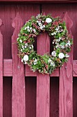 Festive Easter wreath on traditional red picket fence