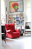 Roter Sessel im Arbeitszimmer mit Bücherregal