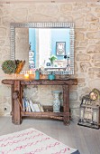 Large mirror above old workbench against stone wall