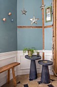 Two side tables in front of blue wall with wainscoting