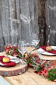 Autumnal place settings on table with rustic wooden boards as place mats and apples on plates