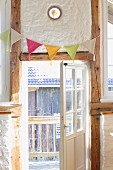 Crocheted bunting hung on half-timbered wall with lattice door