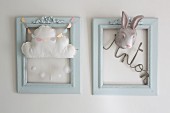 Two blue frames decorated with lettering, cloud mobile and rabbit mask
